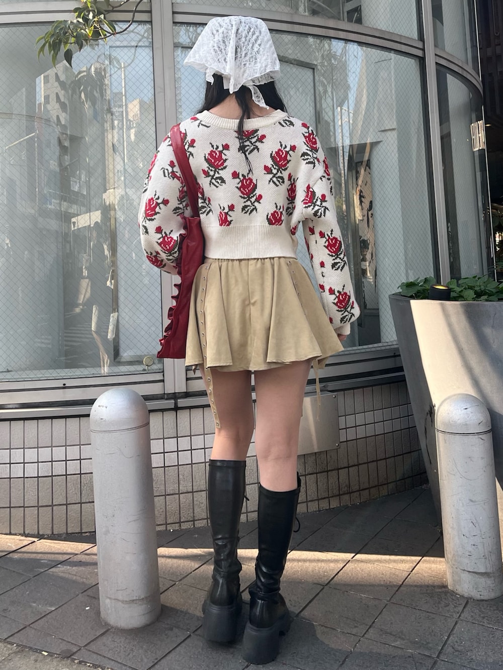 ホワイト系のカーディガン/ボレロ、ベージュ系のスカート、レッド系のトートバッグを着用したレディースの冬コーディネートの4枚目の写真