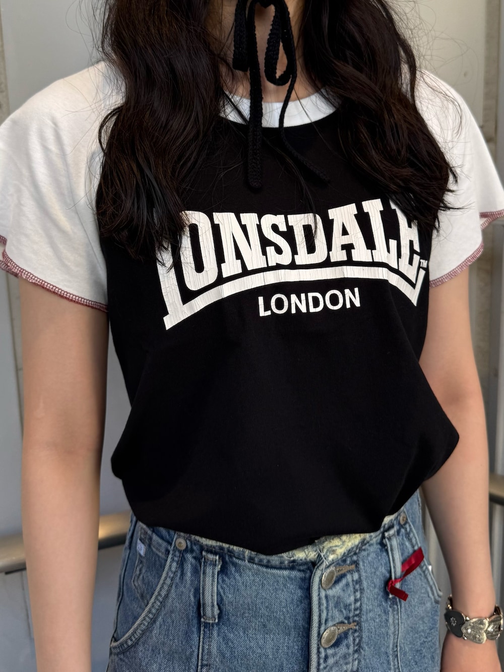 ブラック系のボストンバッグ、ブルー系のデニムパンツ、ブラック系のTシャツ/カットソーを着用したレディースの夏コーディネートの5枚目の写真