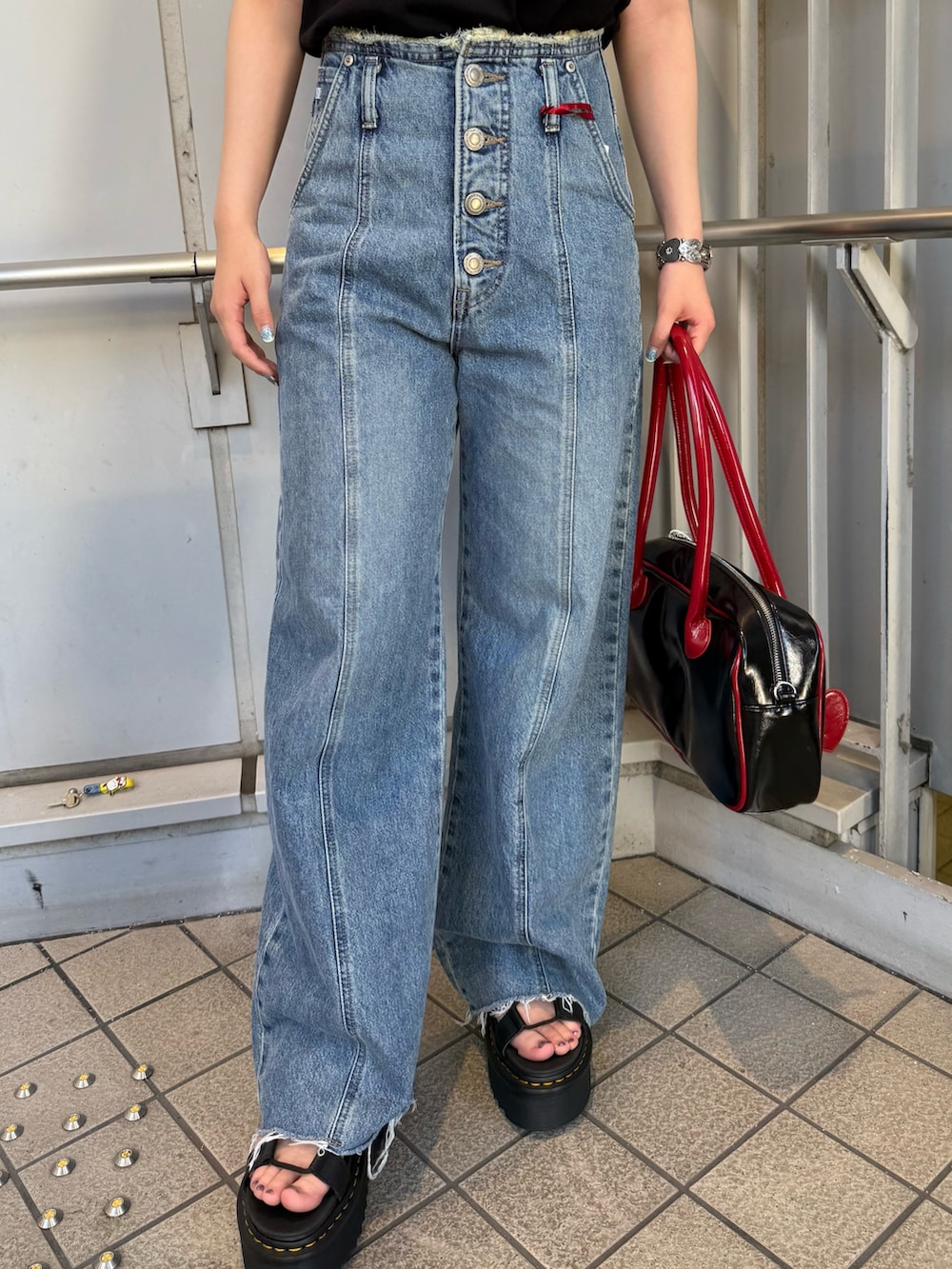 ブラック系のボストンバッグ、ブルー系のデニムパンツ、ブラック系のTシャツ/カットソーを着用したレディースの夏コーディネートの6枚目の写真