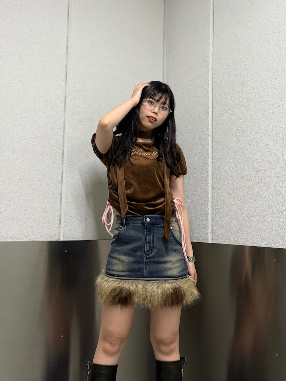 ブラウン系のTシャツ/カットソー、ブラック系のブーツ、ブルー系のスカートを着用したレディースの秋コーディネートの5枚目の写真