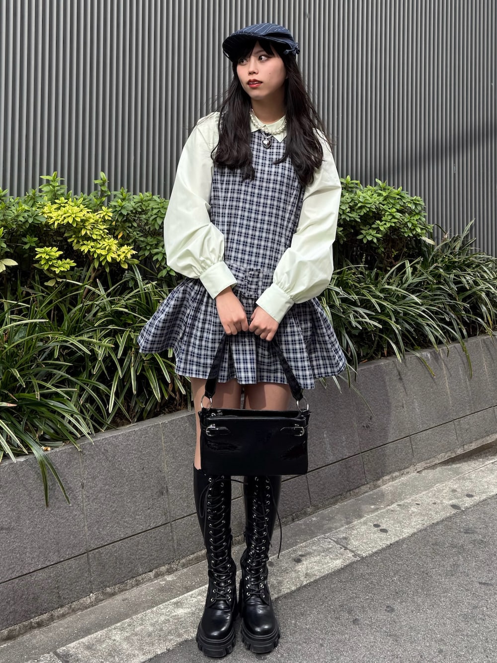 ブルー系のシャツワンピース、ブラック系のブーツ、ブラック系のハンドバッグを着用したレディースの冬コーディネートの2枚目の写真