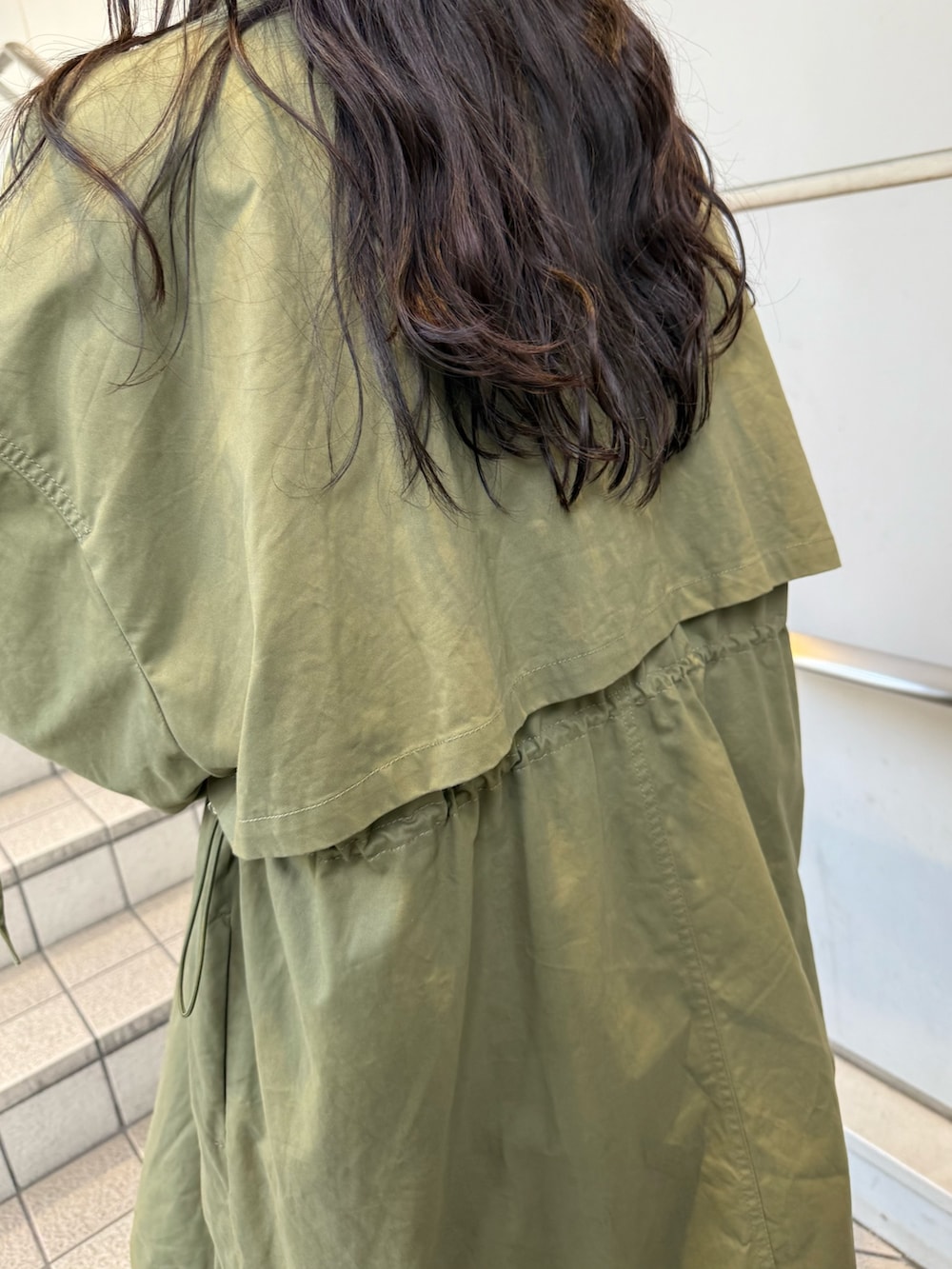 ブラック系のブーツ、グリーン系のモッズコート、ベージュ系のイヤーマフを着用したレディースの秋コーディネートの7枚目の写真