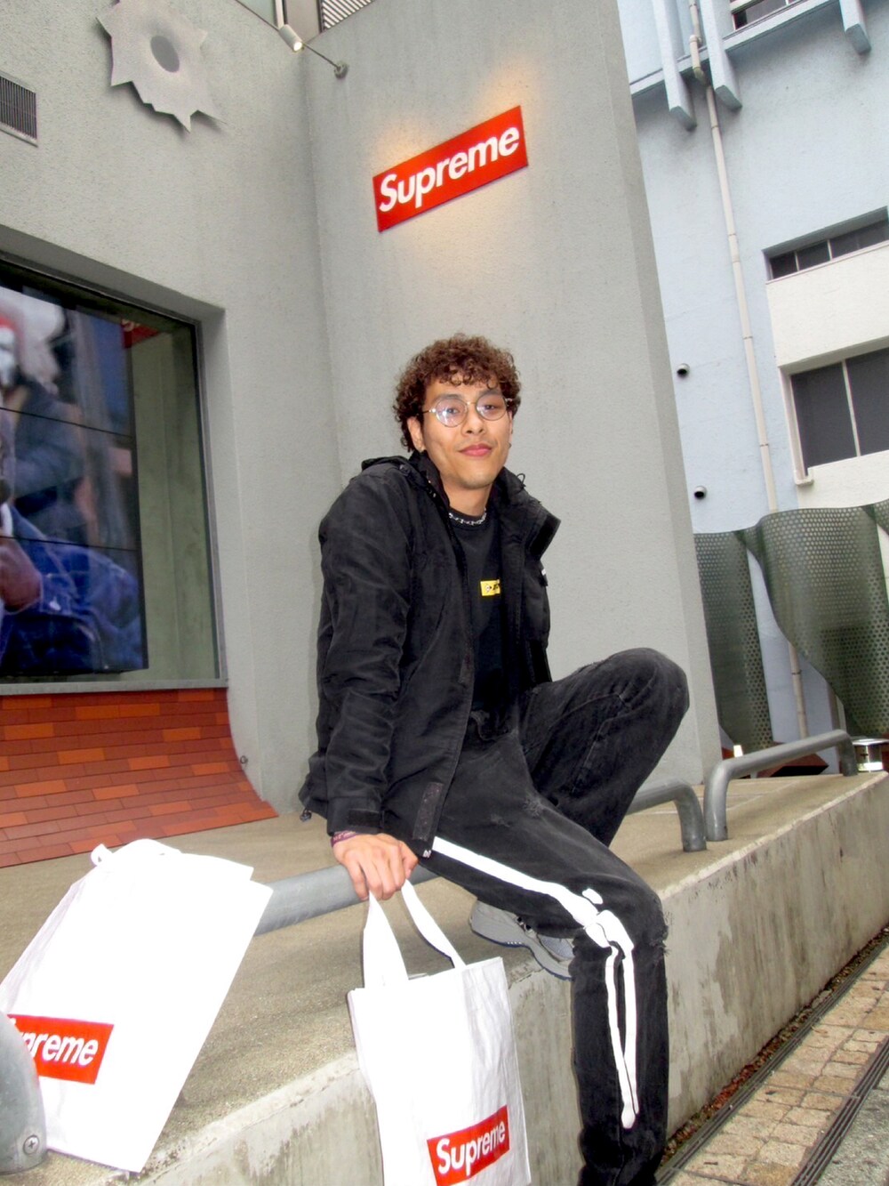 ブラック系のナイロンジャケット、ブラック系のスウェット、グレー系のスニーカーを着用したメンズの秋コーディネートの3枚目の写真