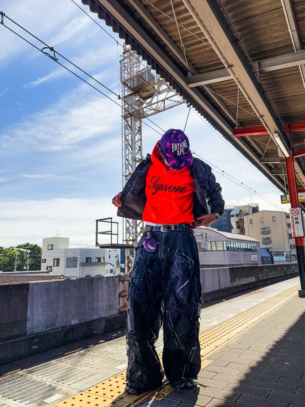 ブラック系のデニムパンツ、オレンジ系のスウェット、ブラック系のデニムジャケットを着用したメンズの秋コーディネートの3枚目の写真