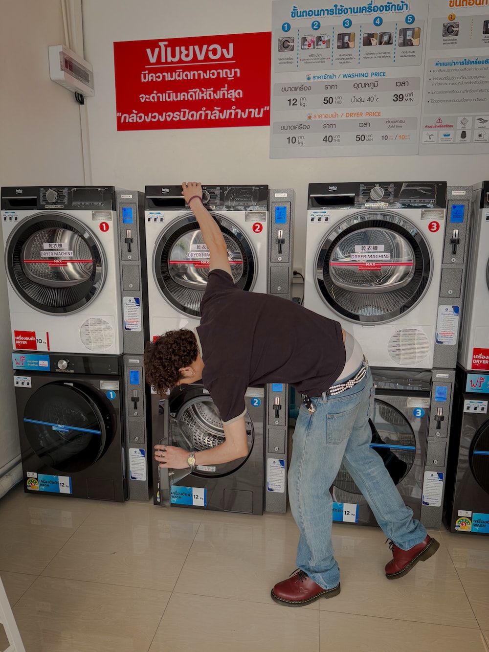 ブラック系のTシャツ/カットソー、ブルー系のデニムパンツ、レッド系のブーツを着用したメンズの秋コーディネートの3枚目の写真