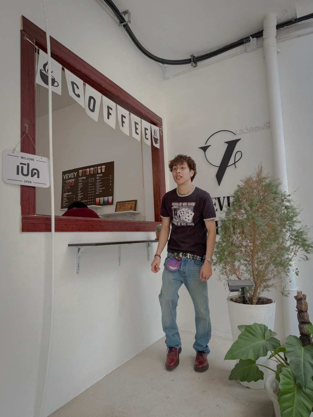 ブラック系のTシャツ/カットソー、ブルー系のデニムパンツ、レッド系のブーツを着用したメンズの秋コーディネートの4枚目の写真