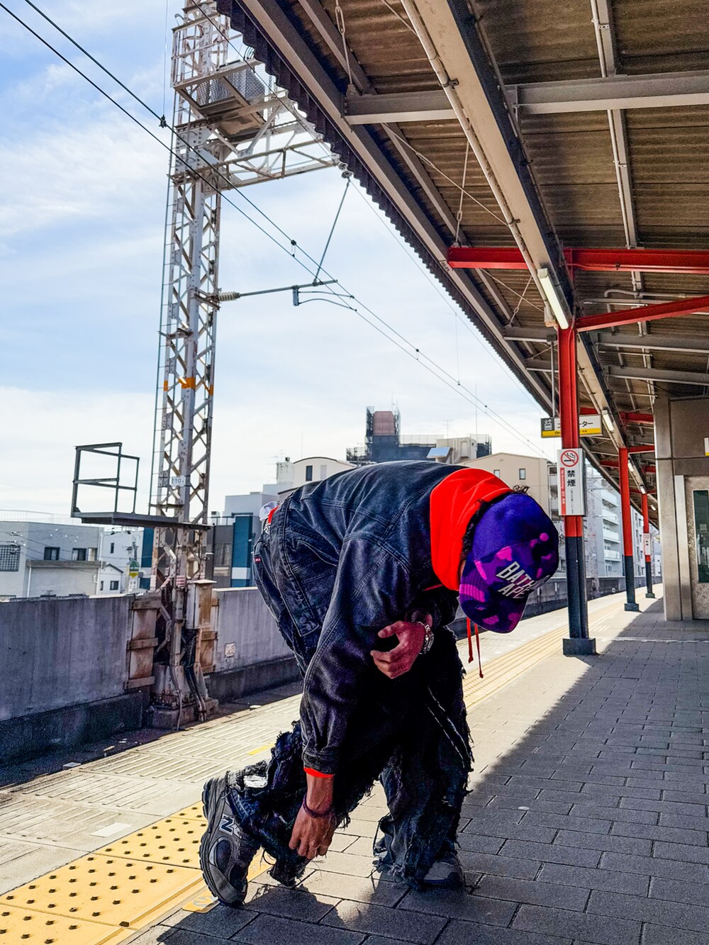 ブラック系のデニムパンツ、オレンジ系のスウェット、ブラック系のデニムジャケットを着用したメンズの秋コーディネートの2枚目の写真