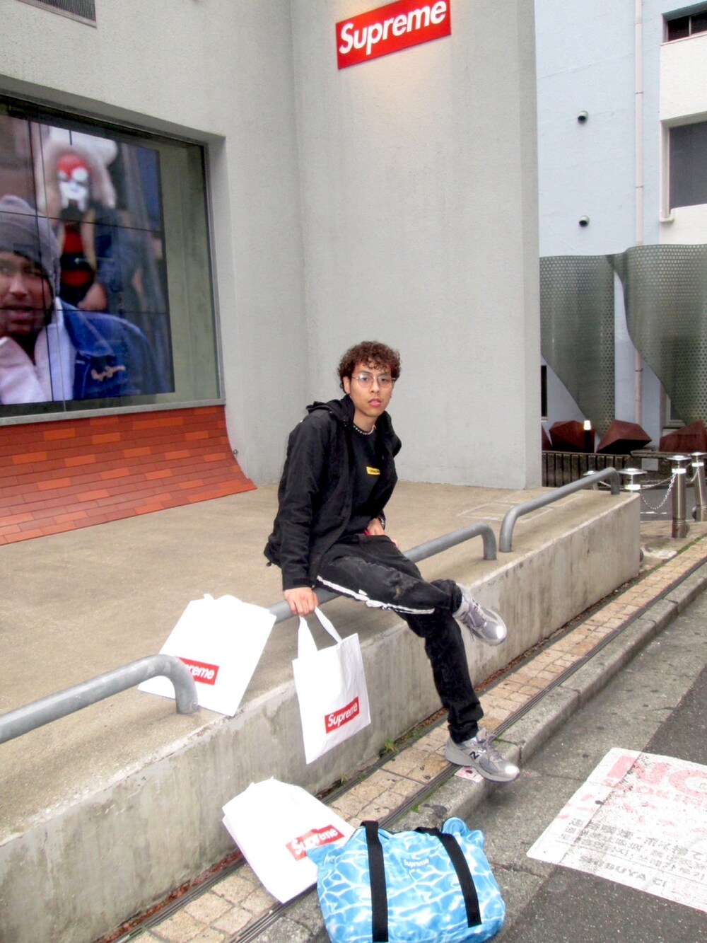 ブラック系のナイロンジャケット、ブラック系のスウェット、グレー系のスニーカーを着用したメンズの秋コーディネートの4枚目の写真