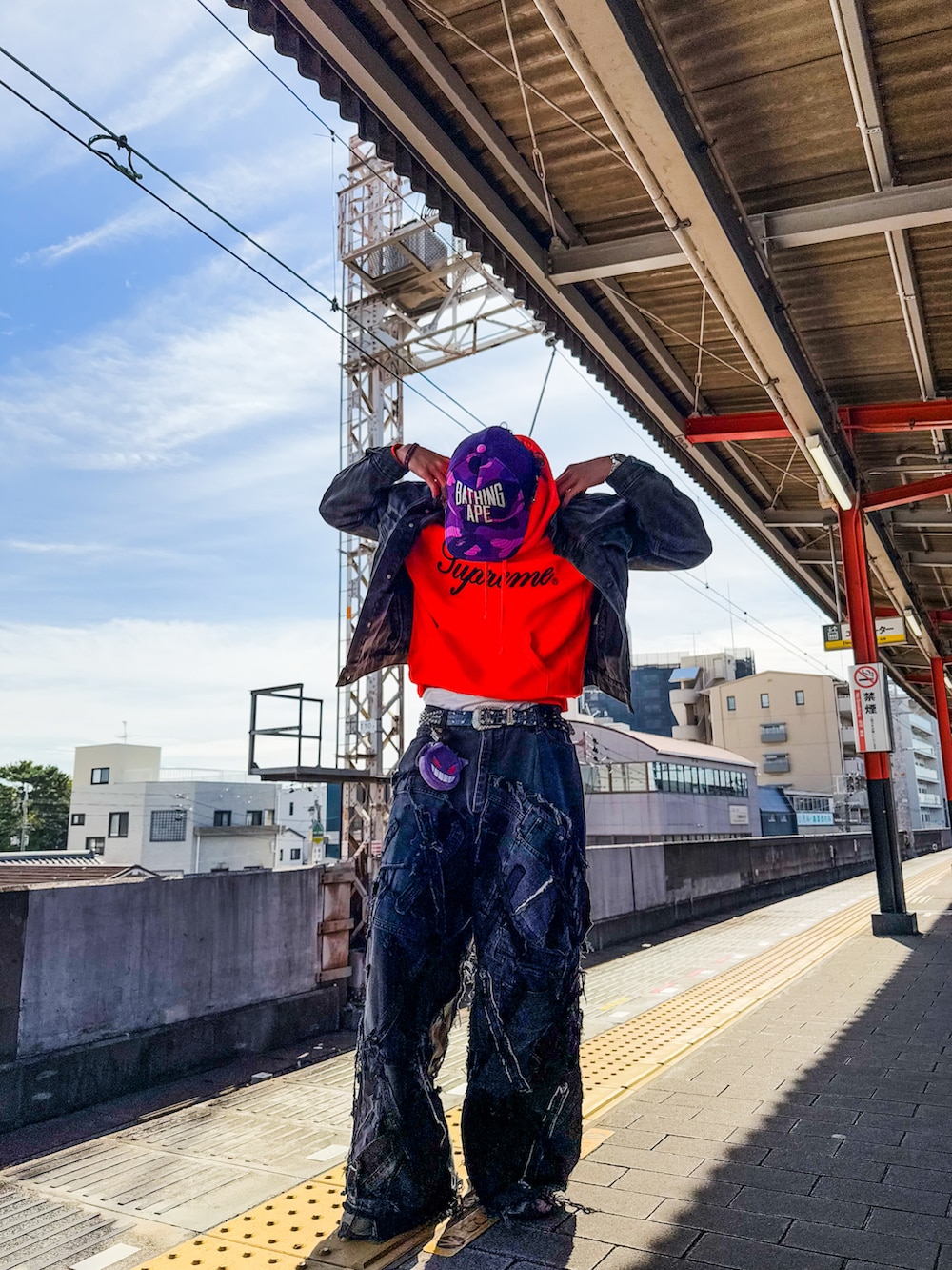 ブラック系のデニムパンツ、オレンジ系のスウェット、ブラック系のデニムジャケットを着用したメンズの秋コーディネートの4枚目の写真