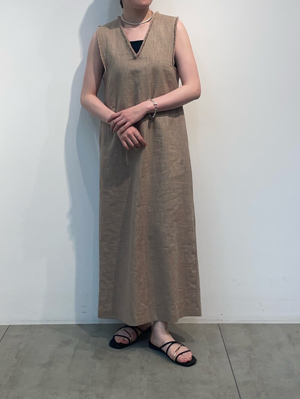 ベージュ系のワンピース、ブラック系のキャミソールを着用したレディースの春コーディネートの2枚目の写真