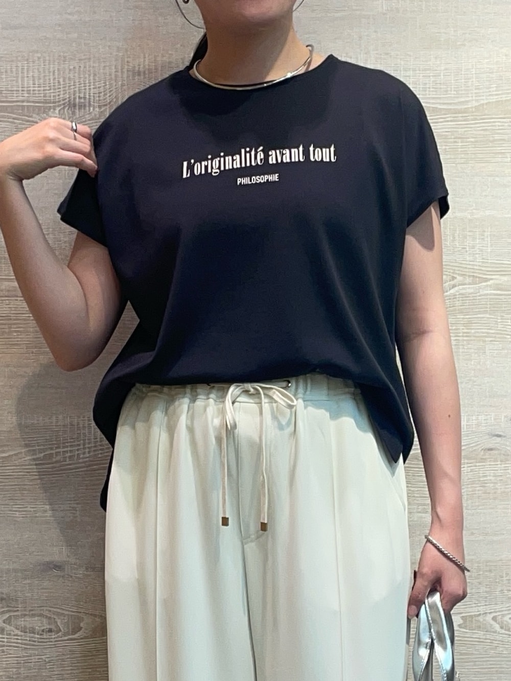 ホワイト系のその他パンツ、ブラック系のTシャツ/カットソーを着用したレディースの夏コーディネートの3枚目の写真