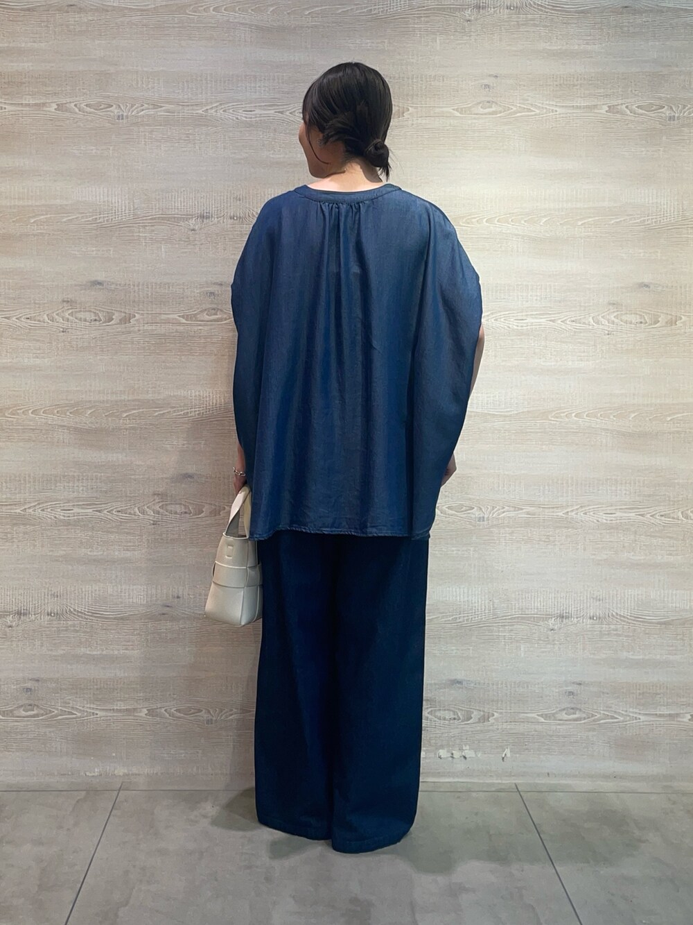 ブルー系のシャツ/ブラウス、ブルー系のデニムパンツ、ホワイト系のトートバッグを着用したレディースの夏コーディネートの2枚目の写真