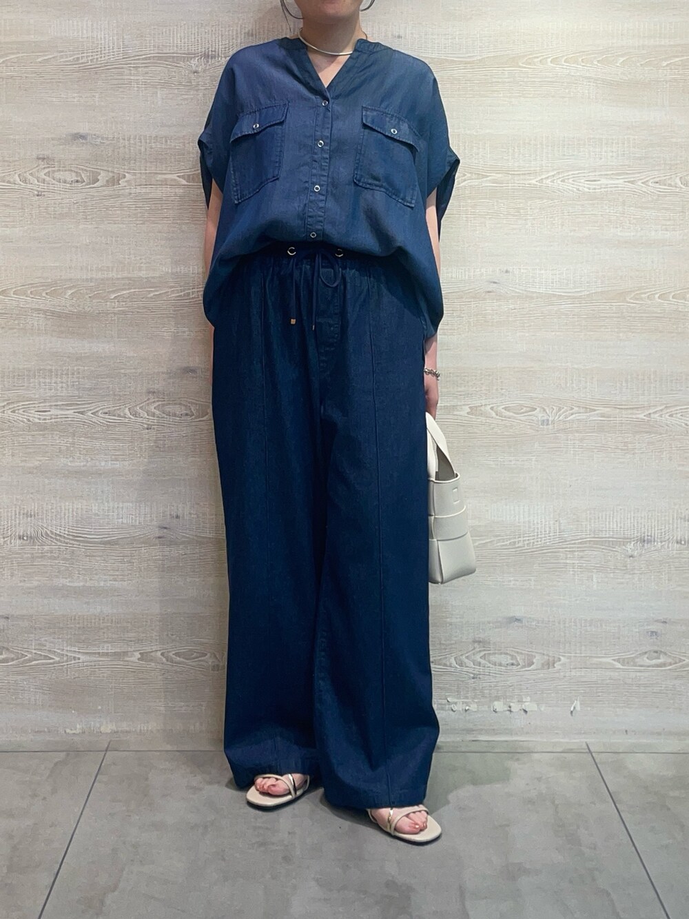 ブルー系のシャツ/ブラウス、ブルー系のデニムパンツ、ホワイト系のトートバッグを着用したレディースの夏コーディネートの3枚目の写真