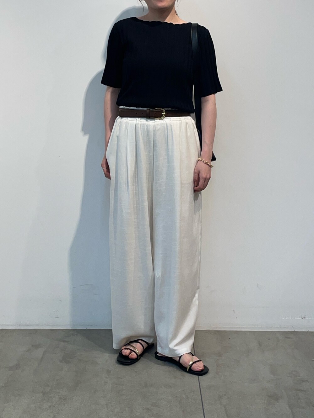 ブラック系のニット/セーター、ホワイト系のその他パンツ、ブラック系のサンダルを着用したレディースの夏コーディネートの2枚目の写真