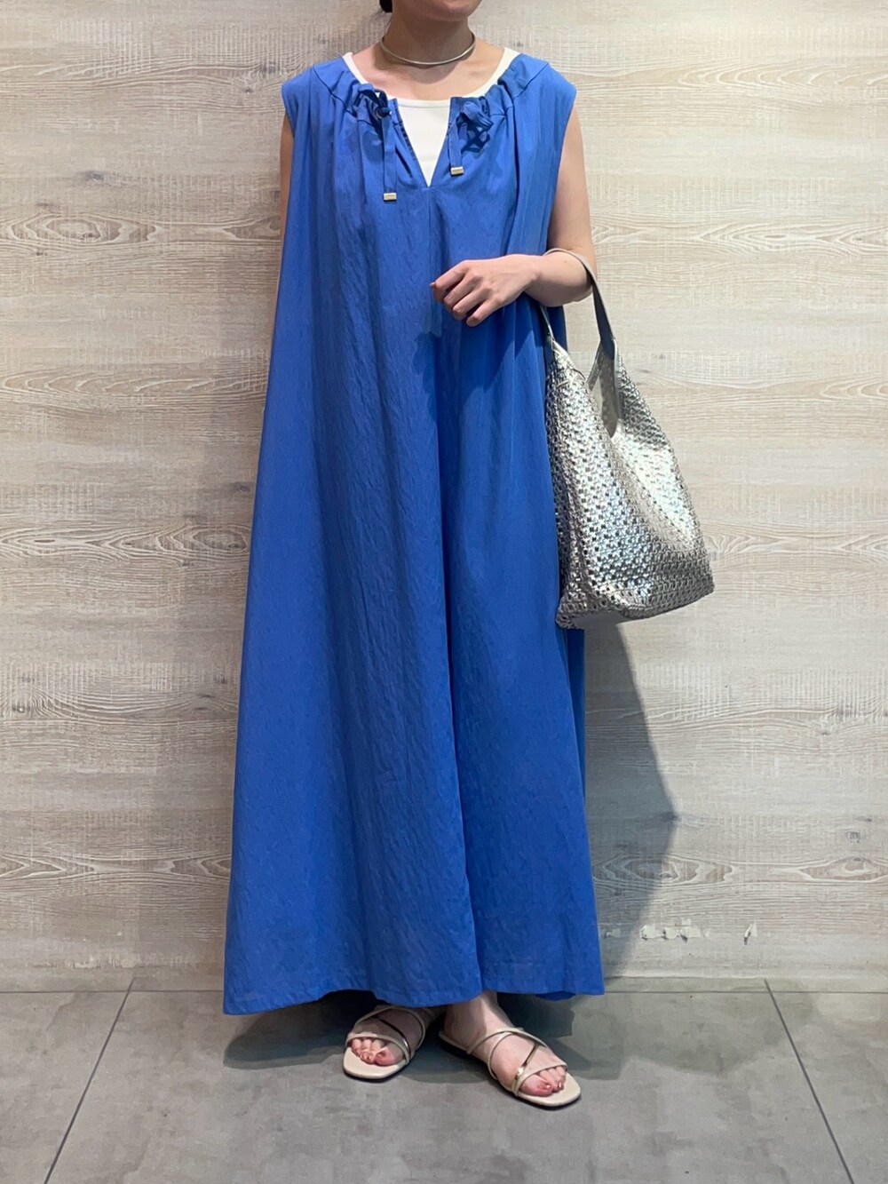 ブルー系のワンピース、ホワイト系のキャミソール、シルバー系のトートバッグを着用したレディースの夏コーディネートの3枚目の写真