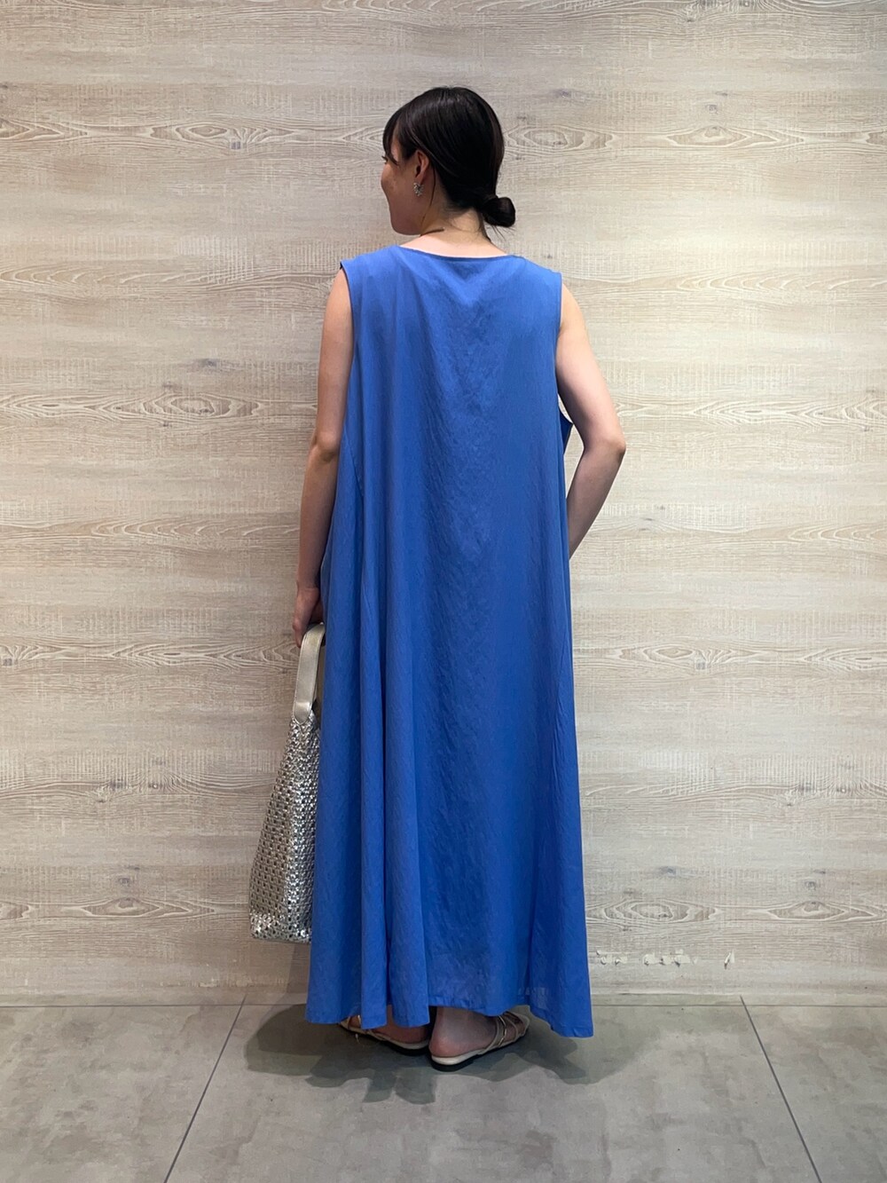 ブルー系のワンピース、ホワイト系のキャミソール、シルバー系のトートバッグを着用したレディースの夏コーディネートの2枚目の写真