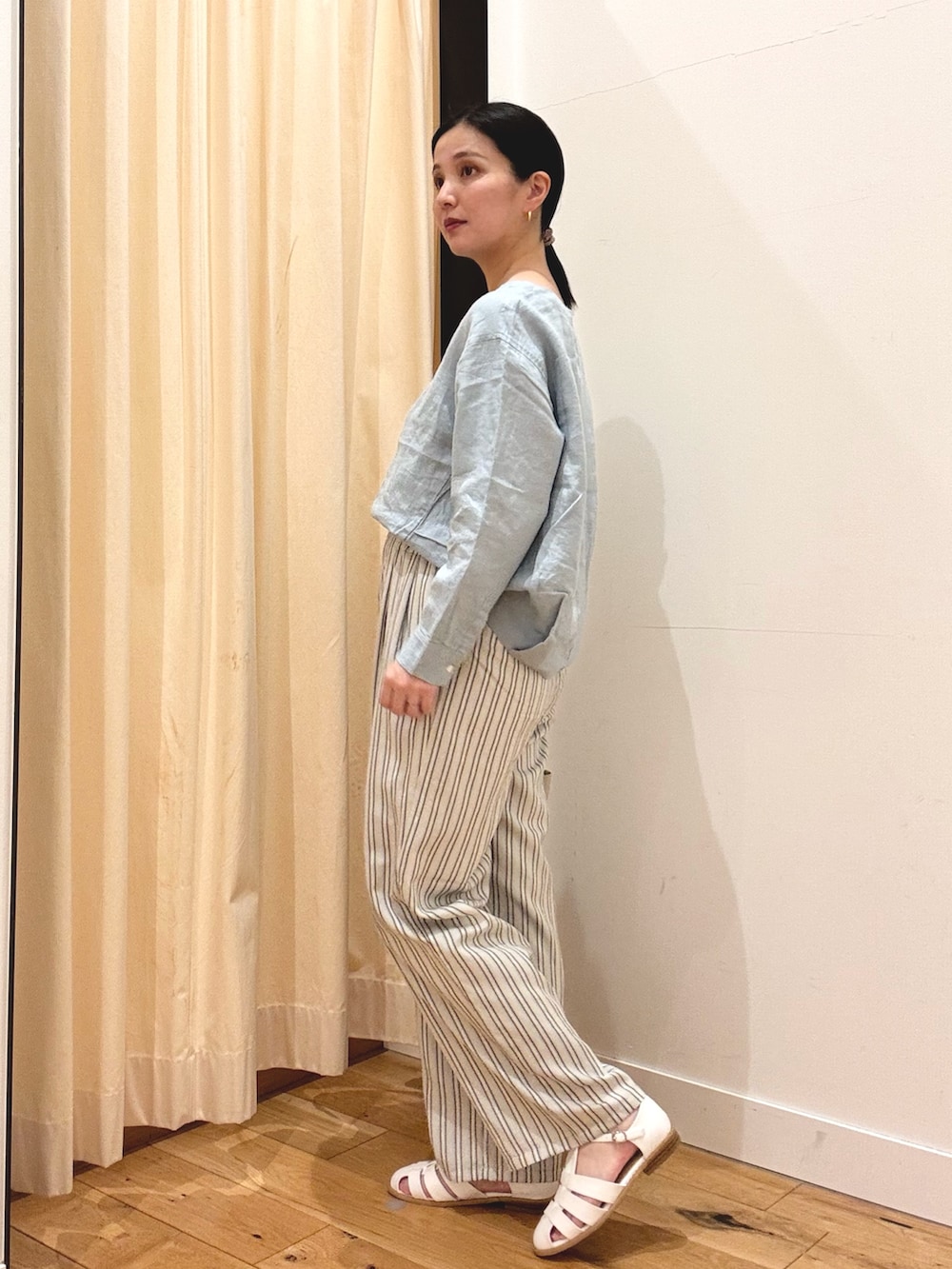 ブルー系のシャツ/ブラウス、グレー系のその他パンツ、ホワイト系のサンダルを着用したレディースの春コーディネートの2枚目の写真