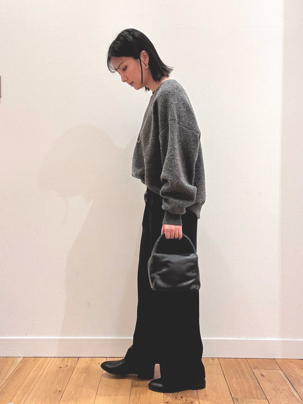 グレー系のその他トップス、ブラック系のその他パンツ、ブラック系のハンドバッグを着用したレディースの秋コーディネートの2枚目の写真