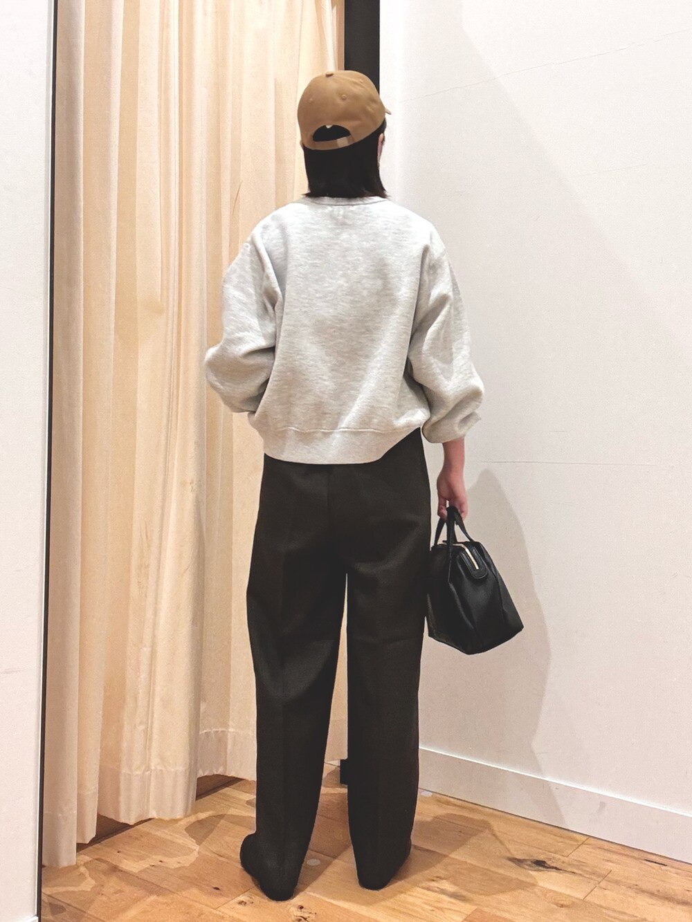 グレー系のニット/セーター、ブラウン系のその他パンツ、ブラック系のボストンバッグを着用したレディースの秋コーディネートの3枚目の写真