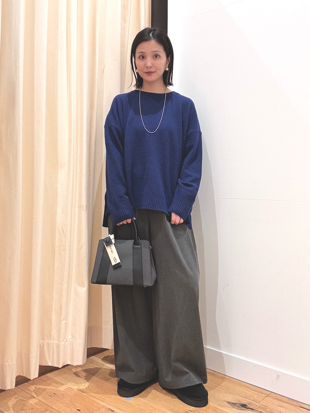 ブラック系のブーツ、ブルー系のニット/セーター、ブルー系のその他アウターを着用したレディースの秋コーディネートの4枚目の写真