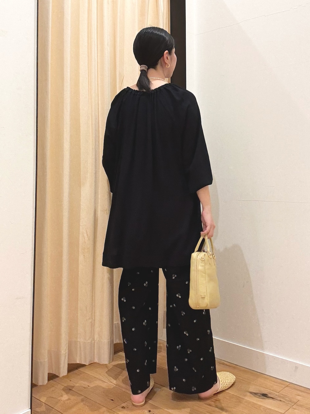 ブラック系のその他トップス、ブラック系のその他パンツ、ホワイト系のボストンバッグを着用したレディースの春コーディネートの2枚目の写真