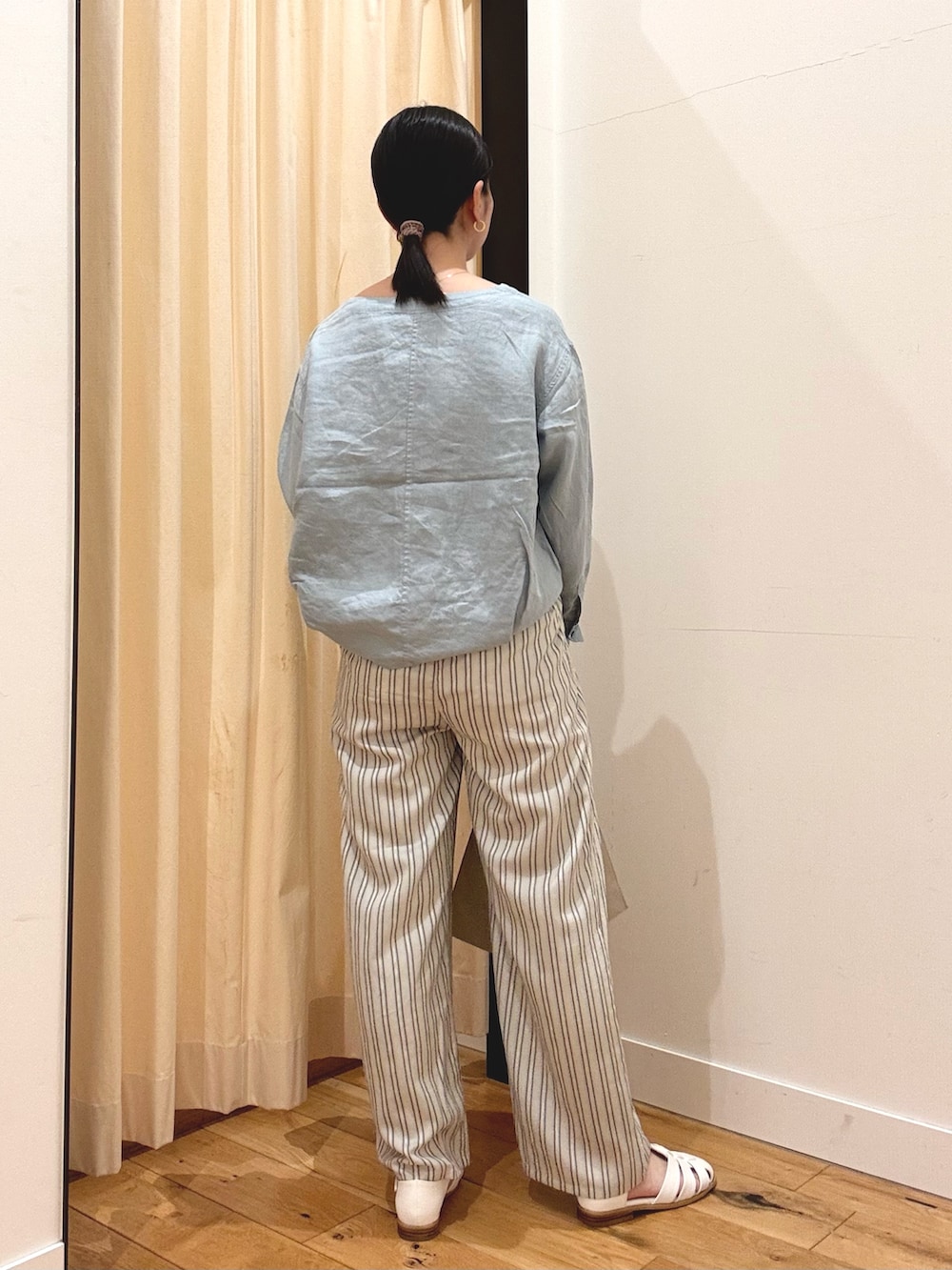 ブルー系のシャツ/ブラウス、グレー系のその他パンツ、ホワイト系のサンダルを着用したレディースの春コーディネートの3枚目の写真