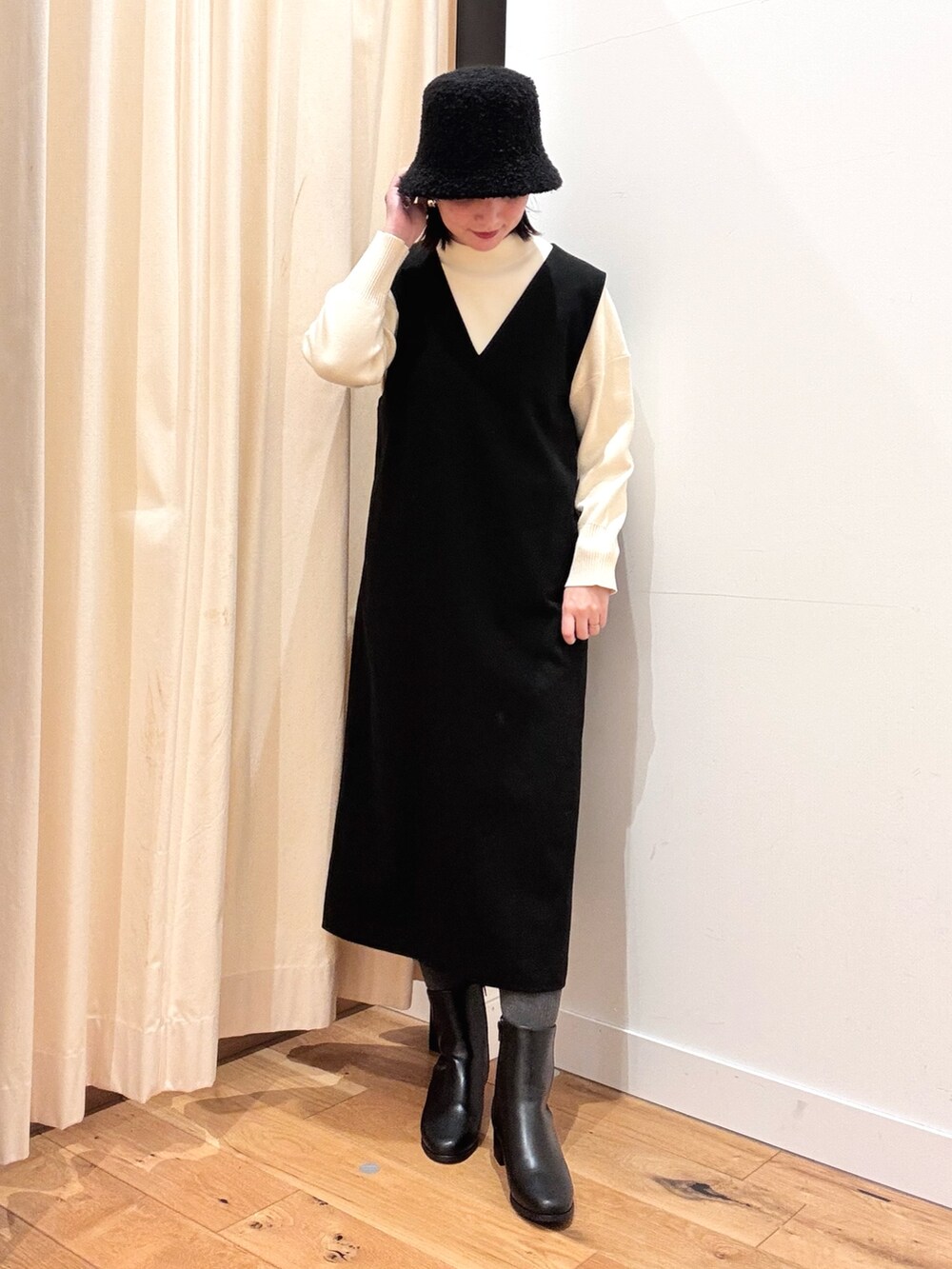 ホワイト系のトートバッグ、ホワイト系のニット/セーター、ブラック系のワンピースを着用したレディースの秋コーディネートの3枚目の写真