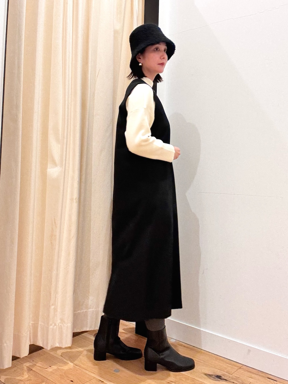 ホワイト系のトートバッグ、ホワイト系のニット/セーター、ブラック系のワンピースを着用したレディースの秋コーディネートの4枚目の写真