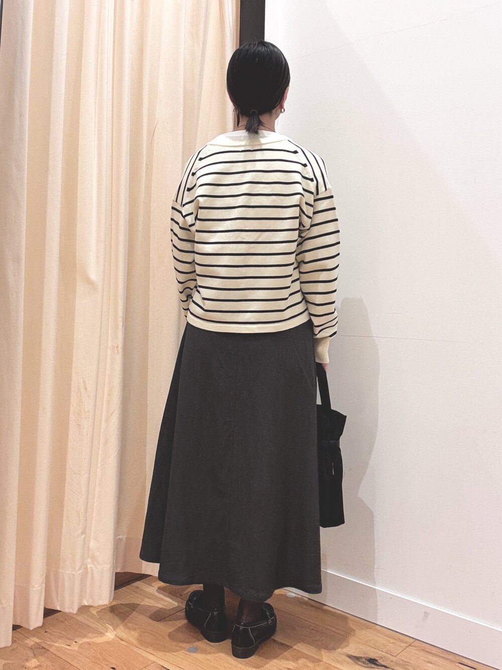 ホワイト系のTシャツ/カットソー、グレー系のスカート、ホワイト系のカーディガン/ボレロを着用したレディースの秋コーディネートの3枚目の写真