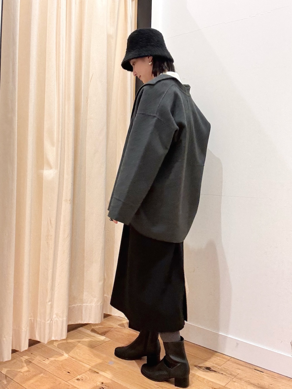 ホワイト系のトートバッグ、ホワイト系のニット/セーター、ブラック系のワンピースを着用したレディースの秋コーディネートの2枚目の写真