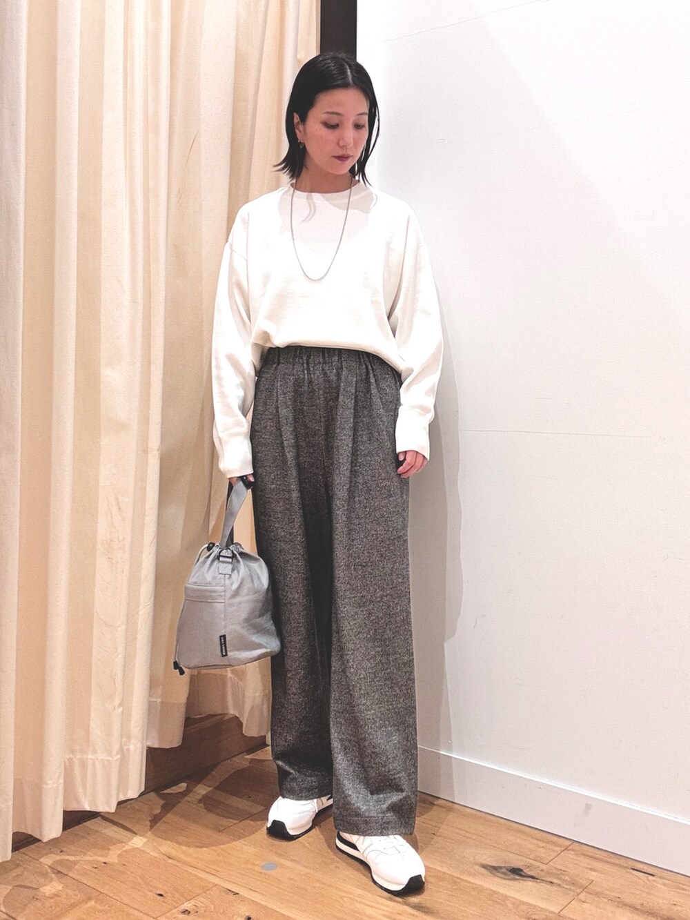 ホワイト系のニット/セーター、ベージュ系のブルゾン、グレー系のその他パンツを着用したレディースの秋コーディネートの4枚目の写真