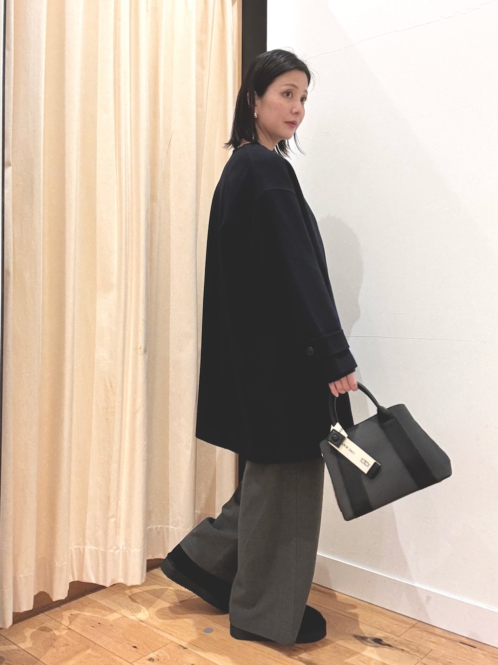 ブラック系のブーツ、ブルー系のニット/セーター、ブルー系のその他アウターを着用したレディースの秋コーディネートの2枚目の写真