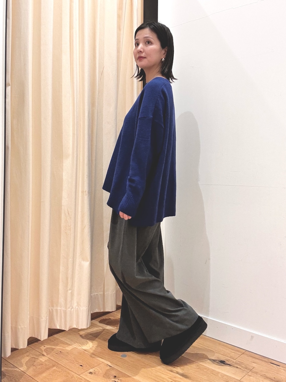 ブラック系のブーツ、ブルー系のニット/セーター、ブルー系のその他アウターを着用したレディースの秋コーディネートの5枚目の写真