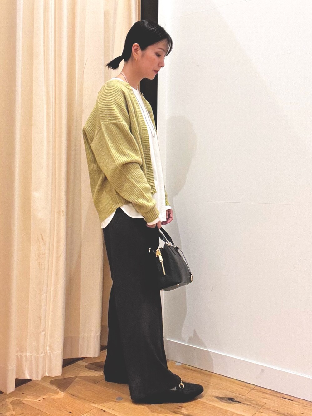 グリーン系のカーディガン/ボレロ、グレー系のその他パンツ、ホワイト系のTシャツ/カットソーを着用したレディースの秋コーディネートの2枚目の写真