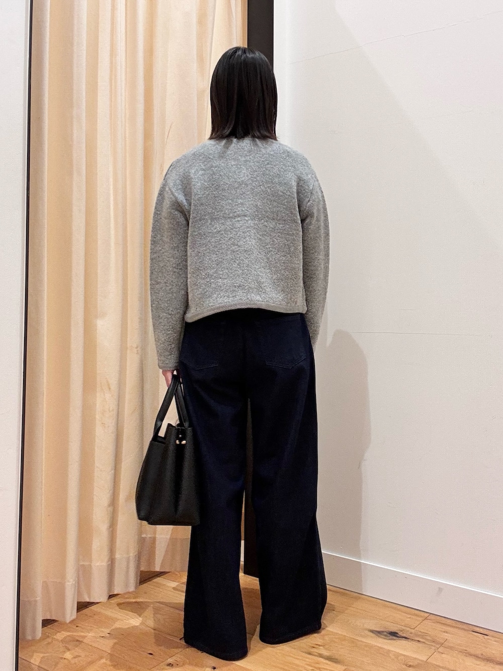 グレー系のカーディガン/ボレロ、ブルー系のデニムパンツ、ブラック系のトートバッグを着用したレディースの秋コーディネートの2枚目の写真