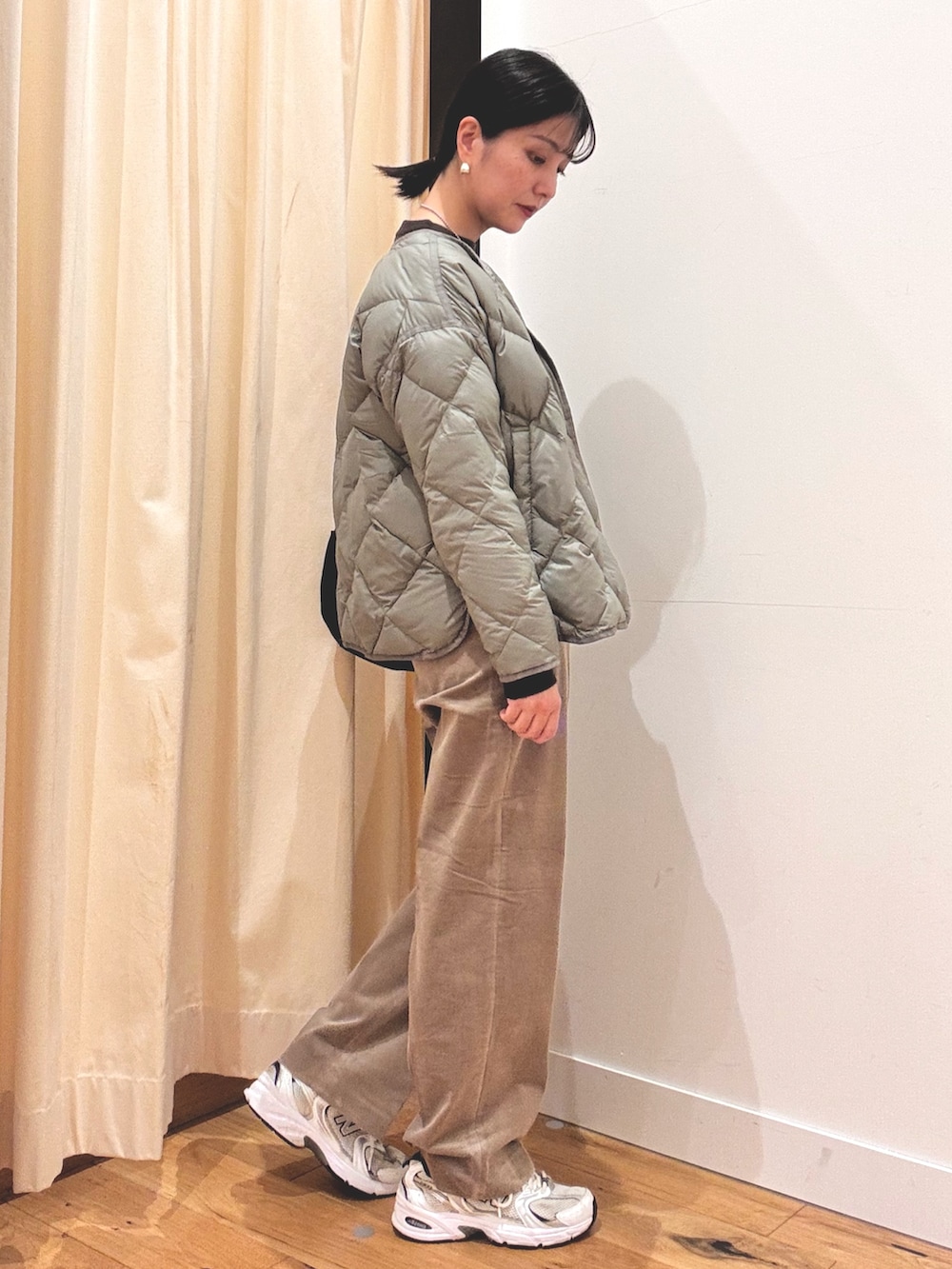 グリーン系のその他アウター、ベージュ系のその他パンツ、ブラウン系のニット/セーターを着用したレディースの秋コーディネートの2枚目の写真