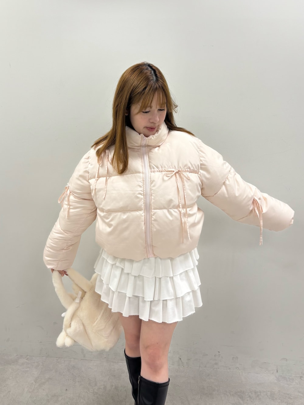 ピンク系のダウンジャケット/コート、ホワイト系のスカートを着用したレディースの冬コーディネートの4枚目の写真