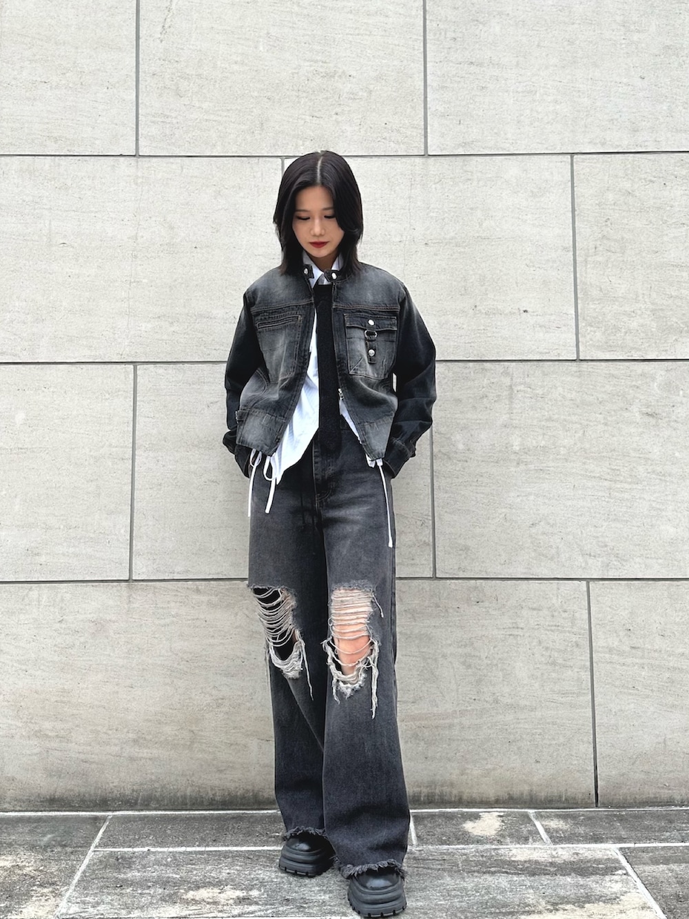 ブラック系のデニムジャケット、ブラック系のネクタイ、ブラック系のデニムパンツを着用したレディースの春コーディネートの2枚目の写真