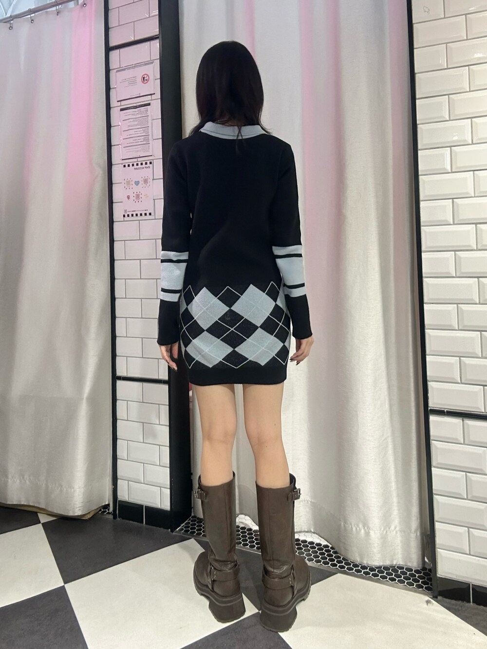 ブラック系のワンピース、ブラウン系のブーツを着用したレディースの冬コーディネートの3枚目の写真