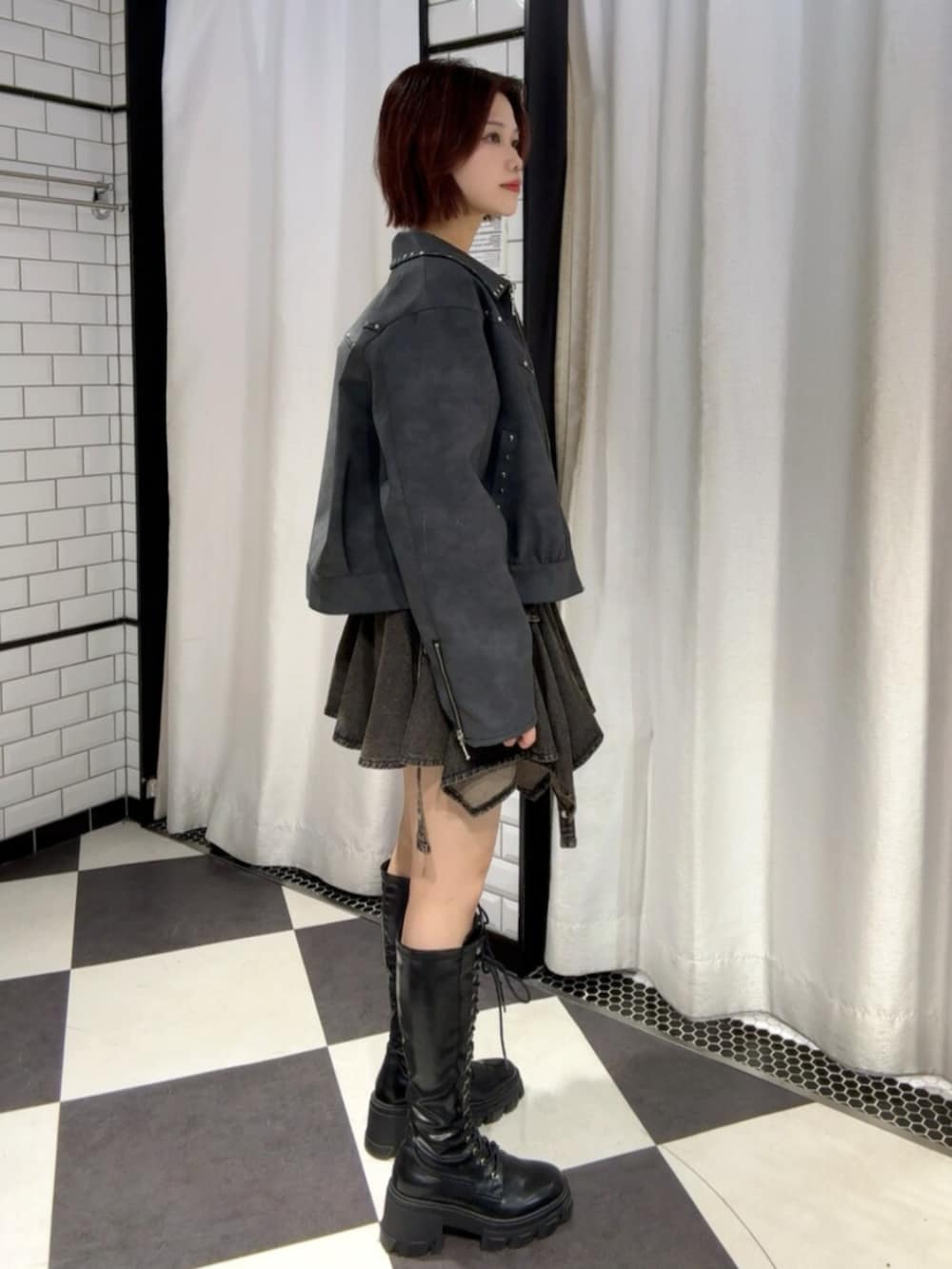 ブラウン系のブルゾン、ブラック系のデニムスカートを着用したレディースの冬コーディネートの2枚目の写真