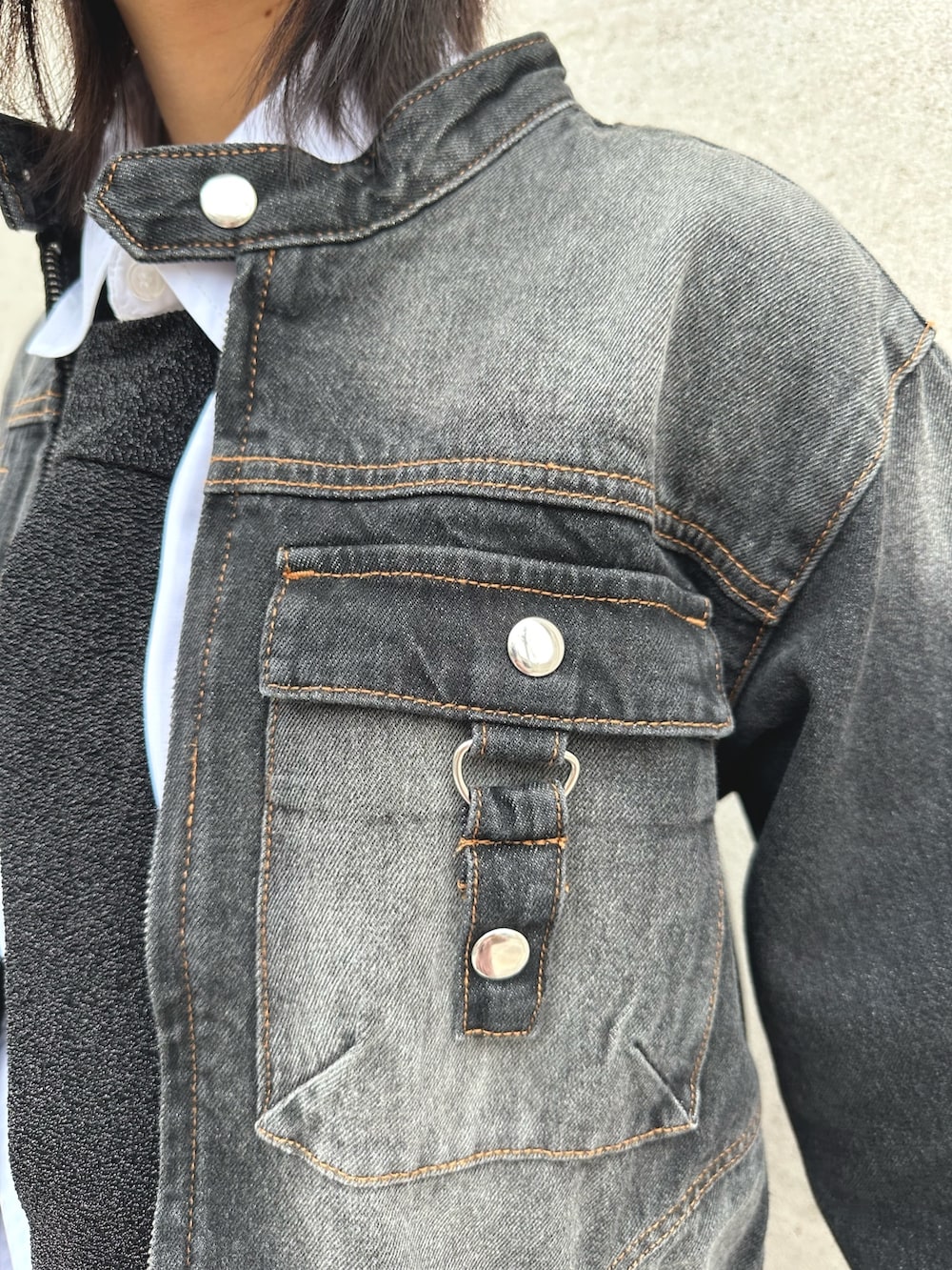 ブラック系のデニムジャケット、ブラック系のネクタイ、ブラック系のデニムパンツを着用したレディースの春コーディネートの3枚目の写真