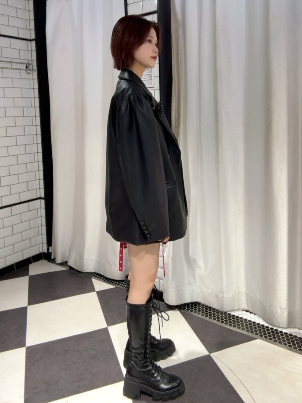 ブラック系のTシャツ/カットソー、レッド系のスカート、ブラック系のテーラードジャケットを着用したレディースの冬コーディネートの2枚目の写真