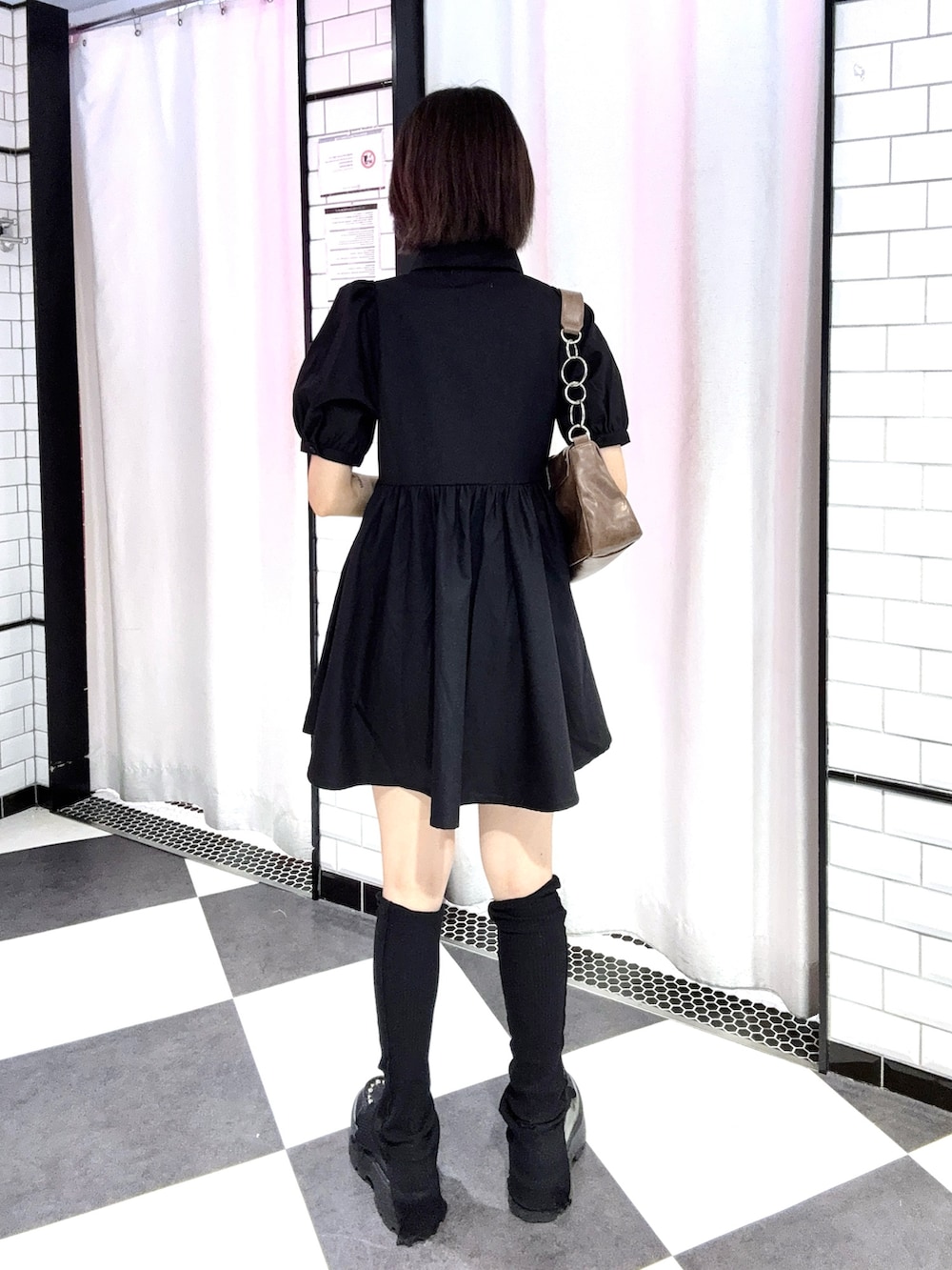 ブラック系のワンピース、ブラック系のローファーを着用したレディースの夏コーディネートの3枚目の写真