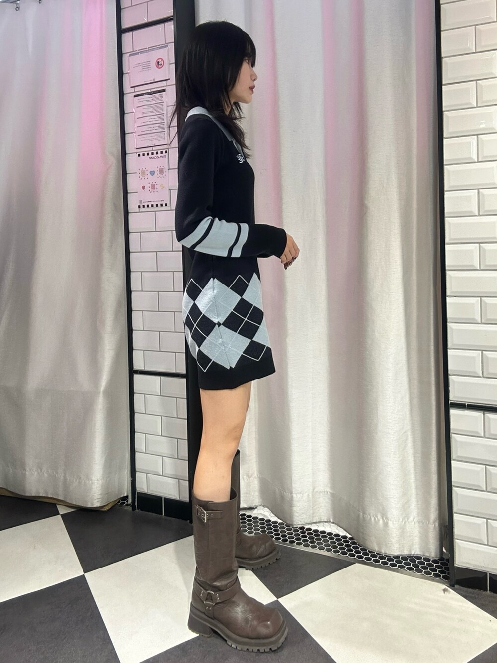 ブラック系のワンピース、ブラウン系のブーツを着用したレディースの冬コーディネートの2枚目の写真