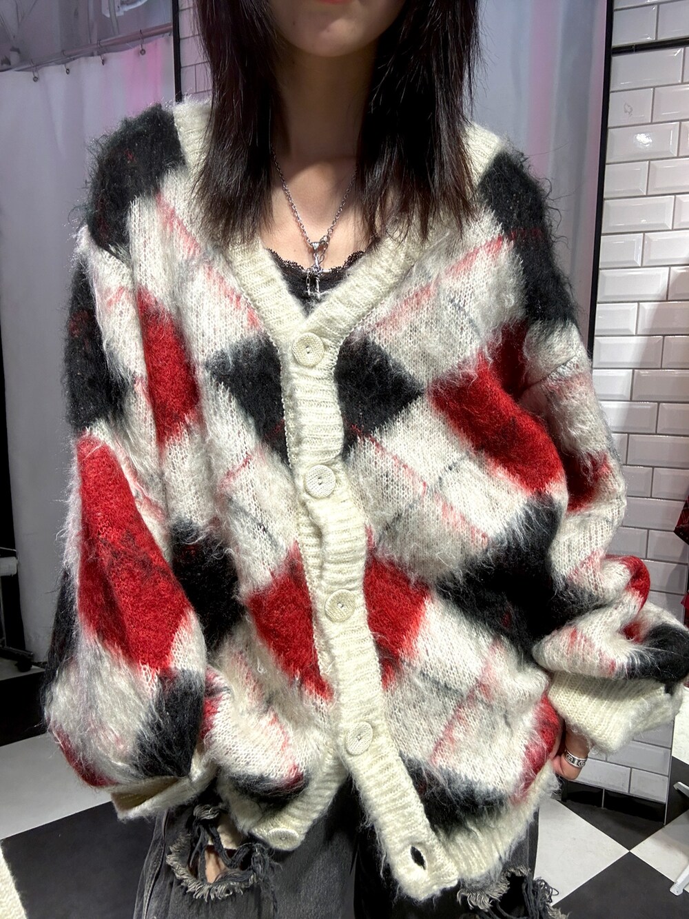 ホワイト系のカーディガン/ボレロ、ブラック系のブーツを着用したレディースの秋コーディネートの4枚目の写真