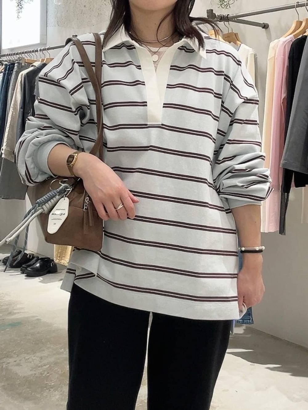 ブラウン系のボストンバッグ、ブラック系のスウェットパンツ、ブルー系のTシャツ/カットソーを着用したレディースの冬コーディネートの2枚目の写真