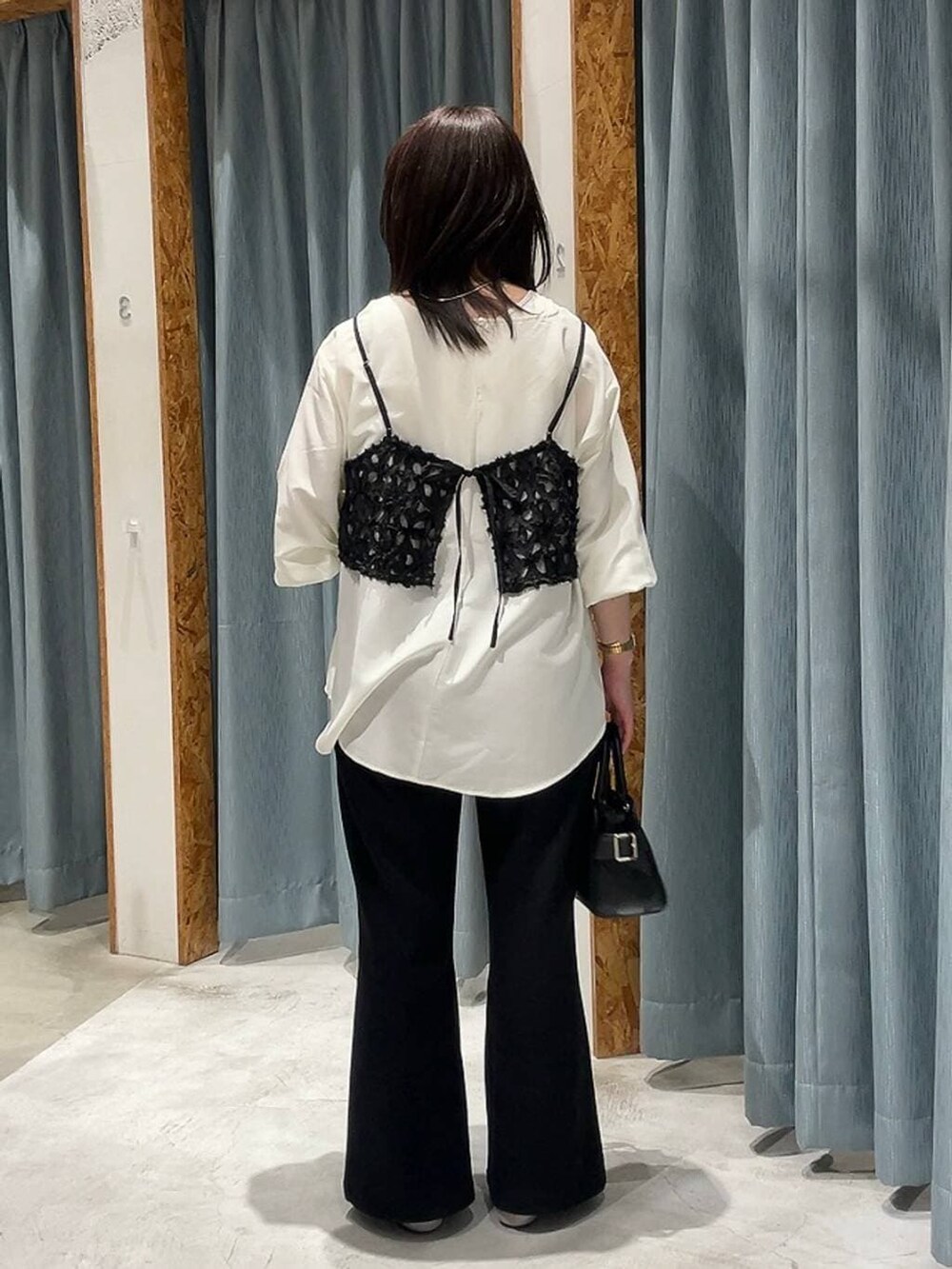 ブラック系のショルダーバッグ、シルバー系のパンプス、ホワイト系のシャツ/ブラウスを着用したレディースの冬コーディネートの3枚目の写真