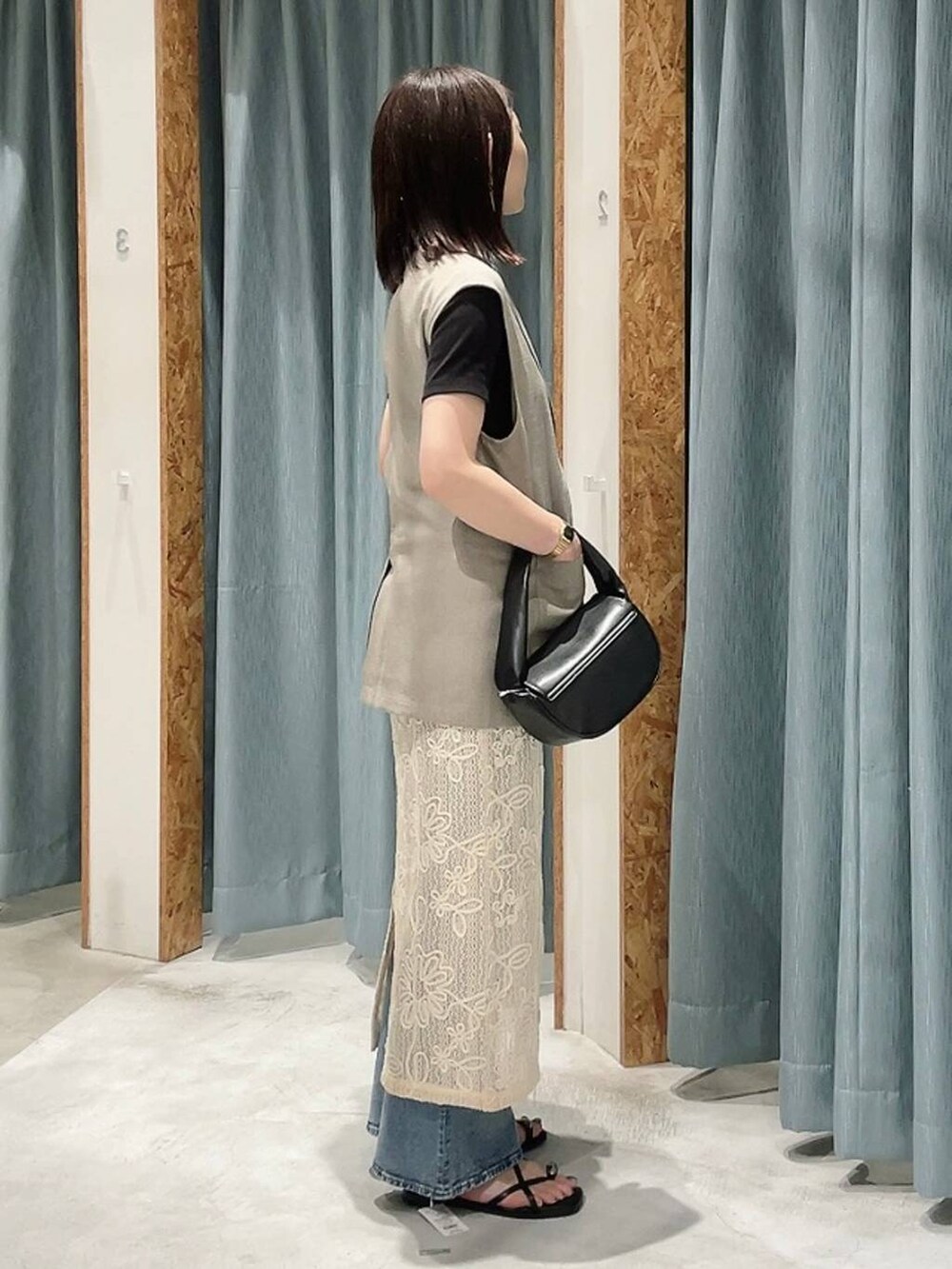 ブラック系のTシャツ/カットソー、ブラック系のハンドバッグ、ブラウン系のサンダルを着用したレディースの春コーディネートの4枚目の写真