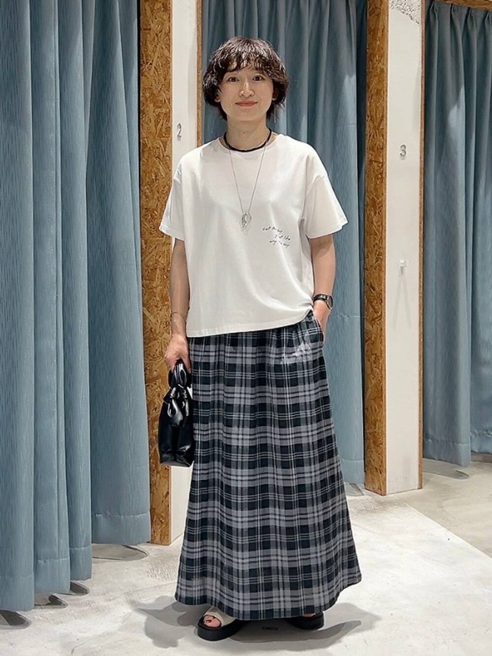 ホワイト系のTシャツ/カットソー、ホワイト系のサンダル、ブラック系のショルダーバッグを着用したレディースの夏コーディネートの9枚目の写真