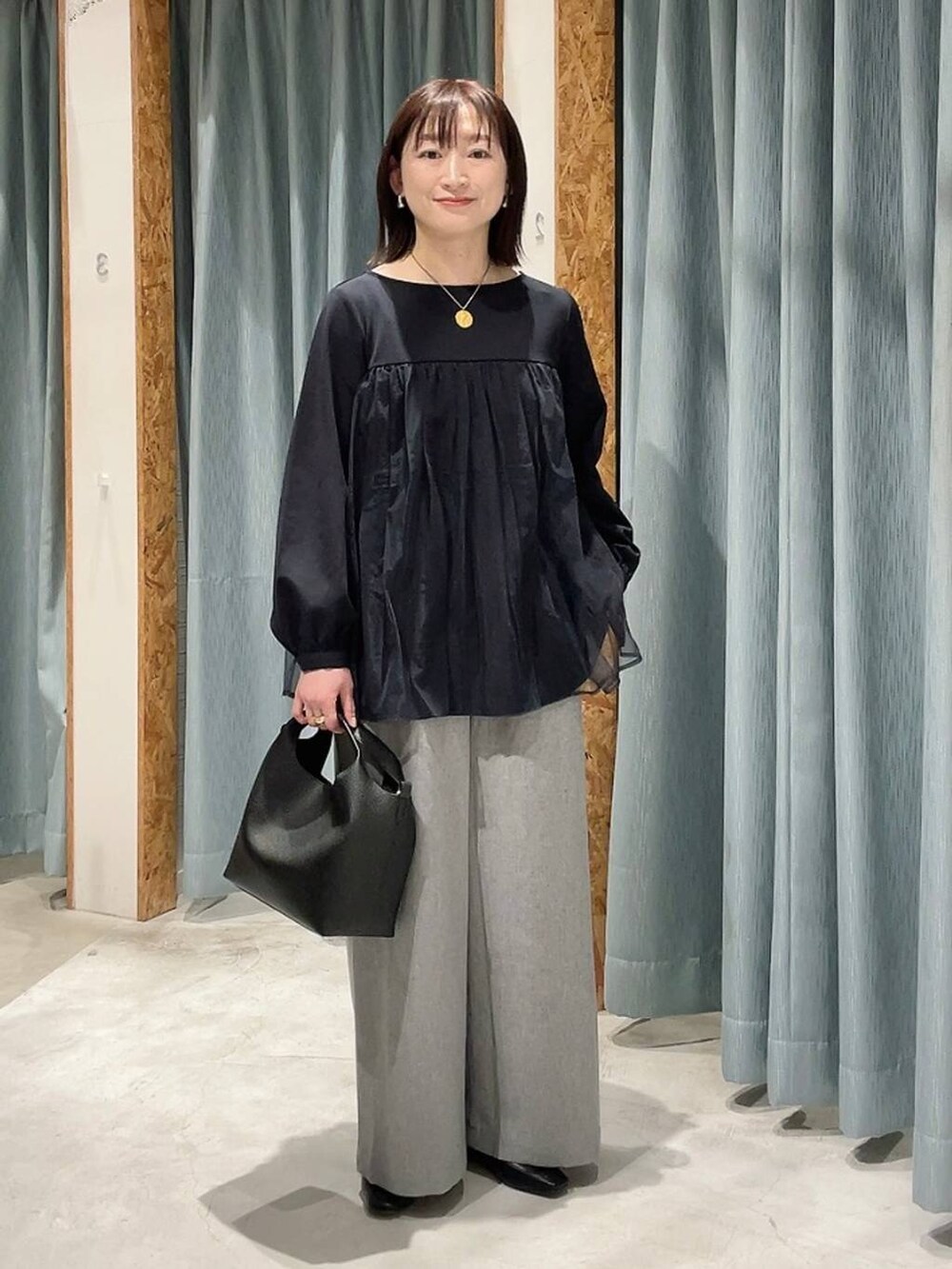 ブルー系のその他パンツ、ブラック系のショルダーバッグ、グレー系のその他パンツを着用したレディースの冬コーディネートの2枚目の写真